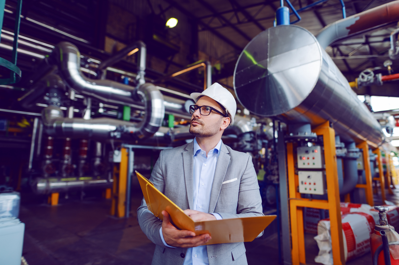 A man inspecting piping systems in a building