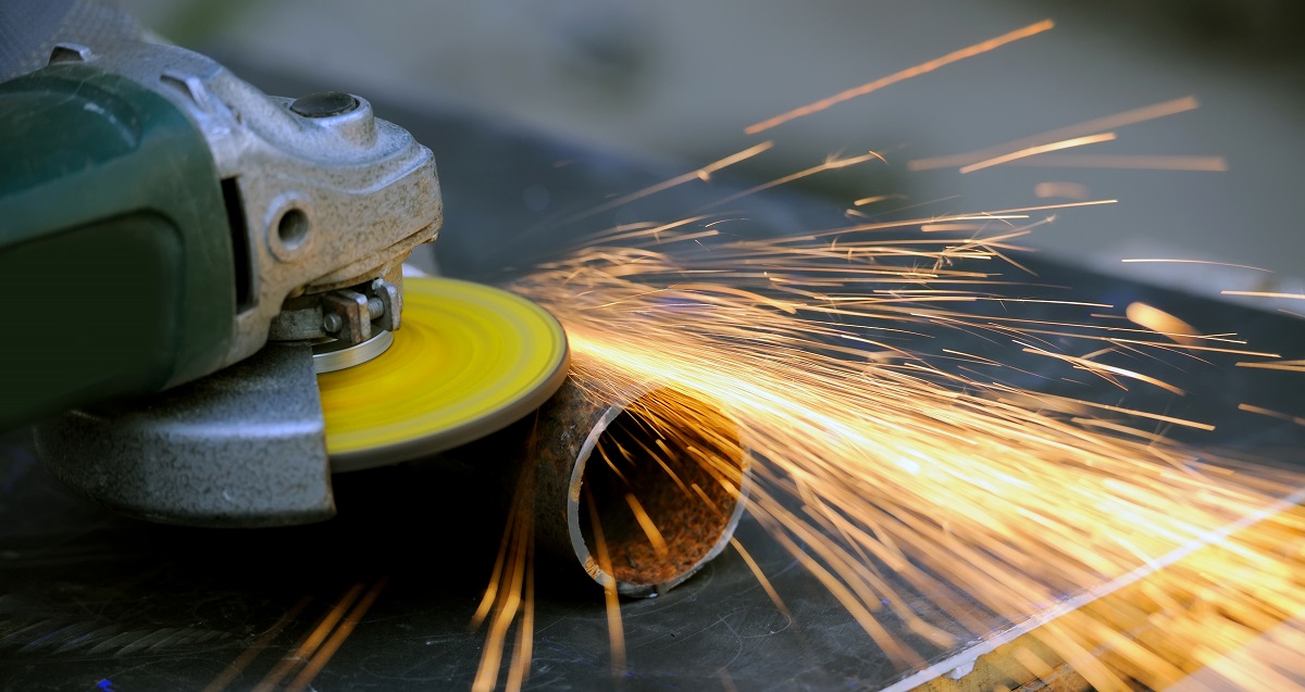 Worker cutting metal with grinder