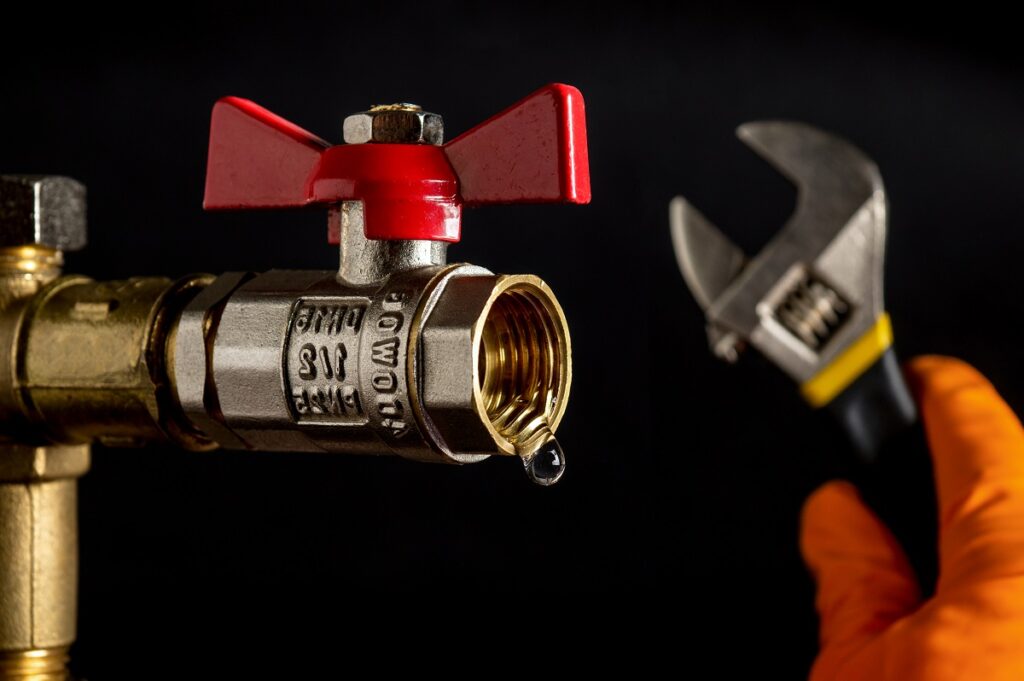 Ball valves close-up on a black background from which water is d