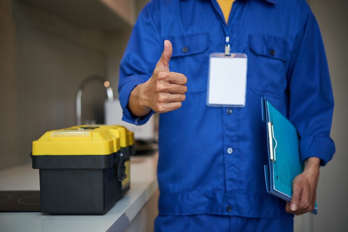 Cropped image of repaiman with tool box showing thumbs-up