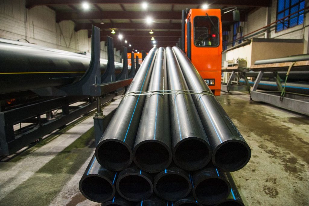 Bundled water pipes prepared for handling in a pipe manufacturing facility