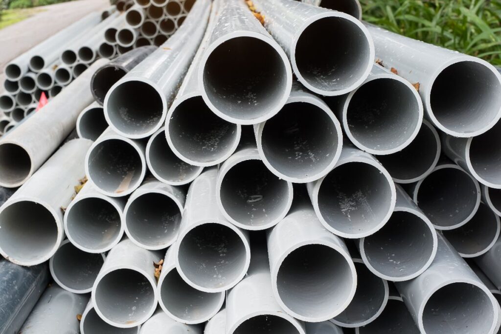 Gray galvanized pipes stacked together, showing round openings and protective coated surfaces