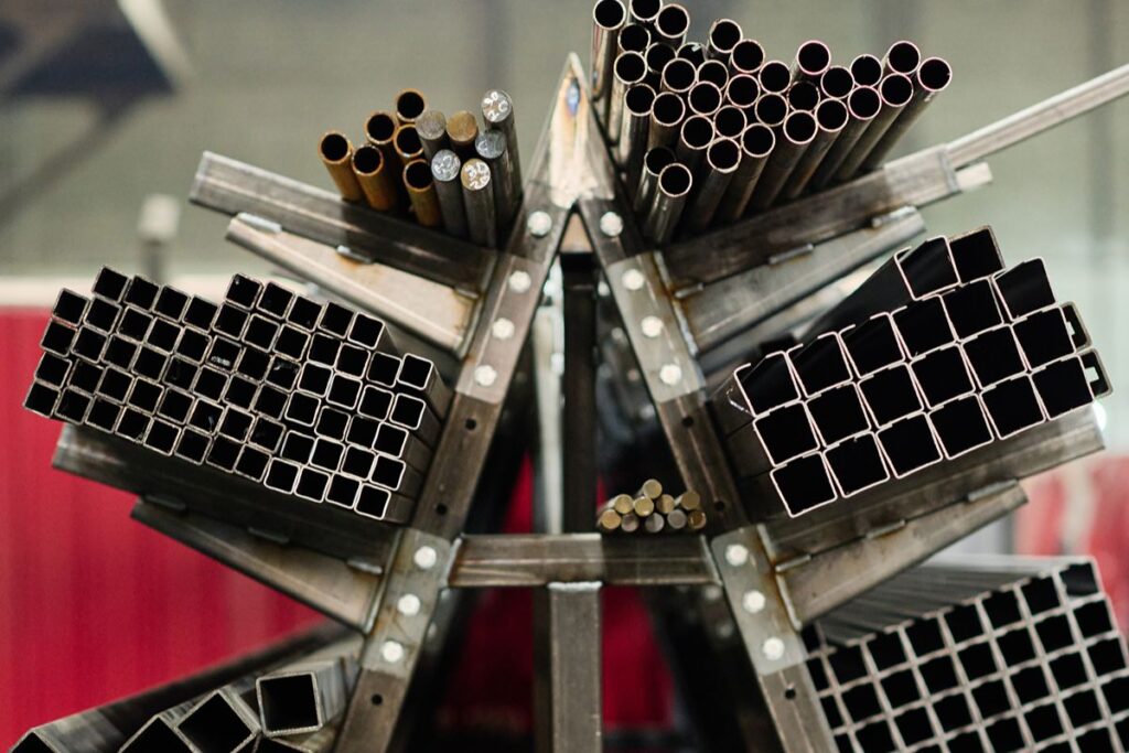 Assorted round and square steel tubes arranged vertically on an industrial storage rack
