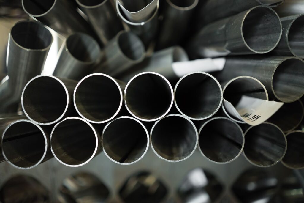 Close-up of stacked round black iron pipes showing their open ends and metal thickness