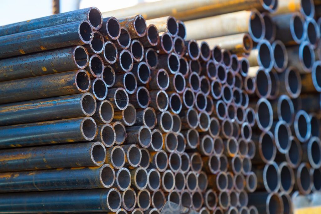 Stacked round steel pipes showing varying diameters for water flow and piping applications