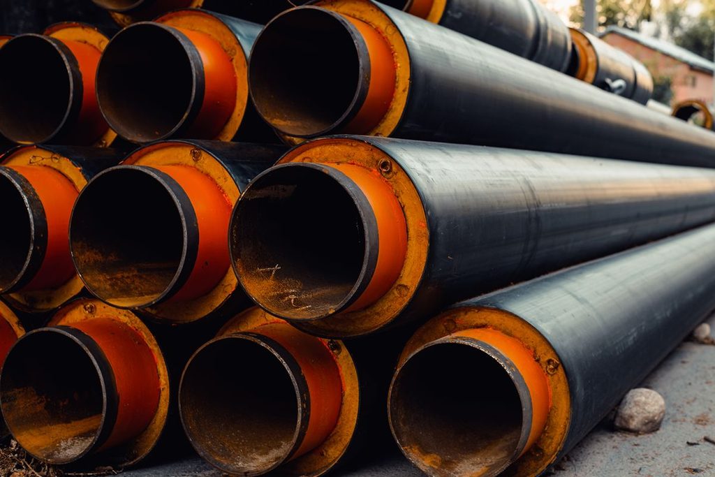 Stacked black iron pipes with large open ends, representing pipe specifications and pressure-related performance considerations