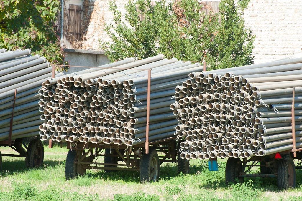 Bundled steel pipes loaded for transport, illustrating delivery delays caused by heavy rain, flooding, and road hazards